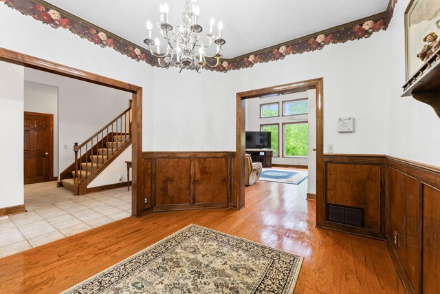 5103 Johnstown Alexandria Rd, Johnstown, OH 43031 - dining space featuring a chandelier, light wood finished floors, wainscoting, and stairs