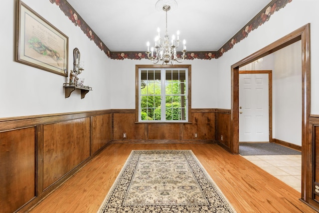 5103 Johnstown Alexandria Rd, Johnstown, OH 43031 - unfurnished dining area featuring a chandelier, light wood-style flooring, a wainscoted wall, and wooden walls