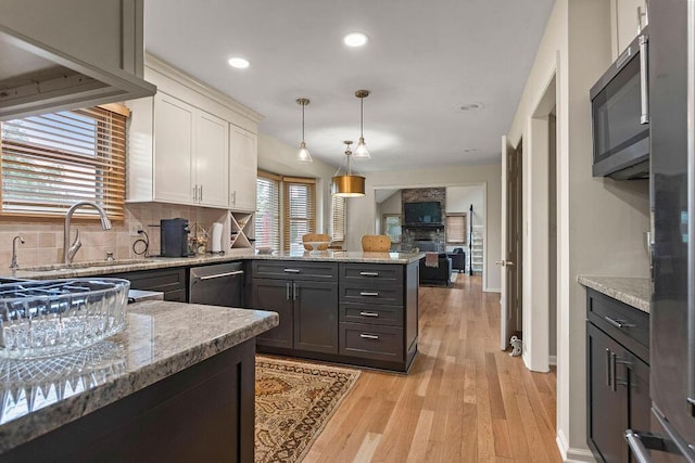 4606 Gershwin Ct, Grove City, OH 43123 - kitchen featuring a sink, stainless steel appliances, white cabinets, decorative backsplash, and a peninsula
