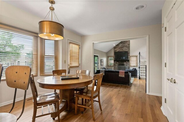 4606 Gershwin Ct, Grove City, OH 43123 - dining space featuring hardwood / wood-style floors, a fireplace, lofted ceiling, and baseboards