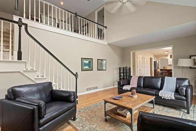 4606 Gershwin Ct, Grove City, OH 43123 - living room featuring wood finished floors, a high ceiling, stairway, baseboards, and a ceiling fan