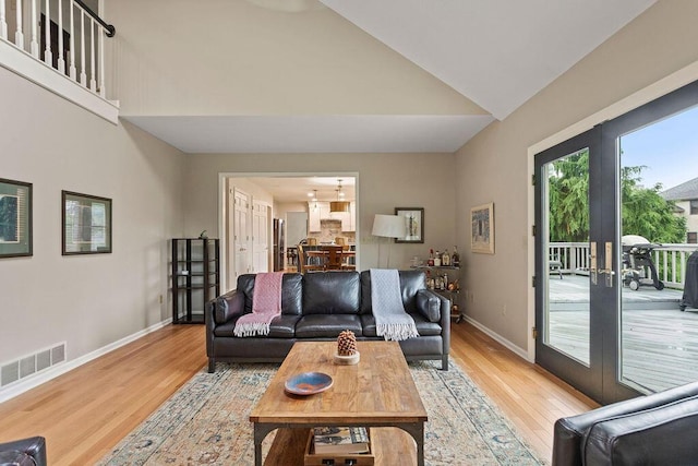 4606 Gershwin Ct, Grove City, OH 43123 - living area featuring french doors, light wood finished floors, baseboards, and high vaulted ceiling