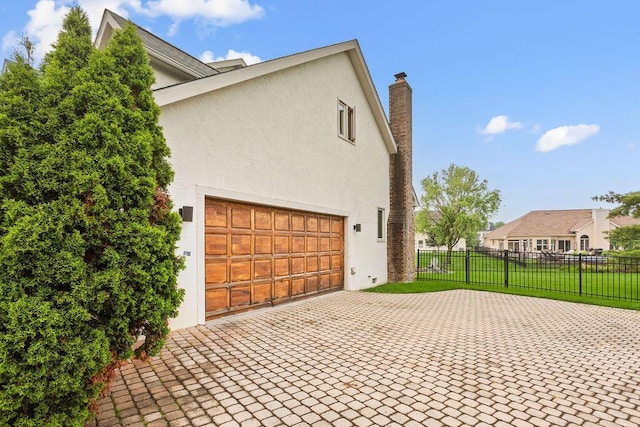 4606 Gershwin Ct, Grove City, OH 43123 - view of home's exterior featuring decorative driveway, stucco siding, and a chimney