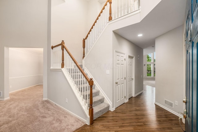 7985 Eric Ct, Lewis Center, OH 43035 - stairway featuring a towering ceiling, baseboards, and wood finished floors