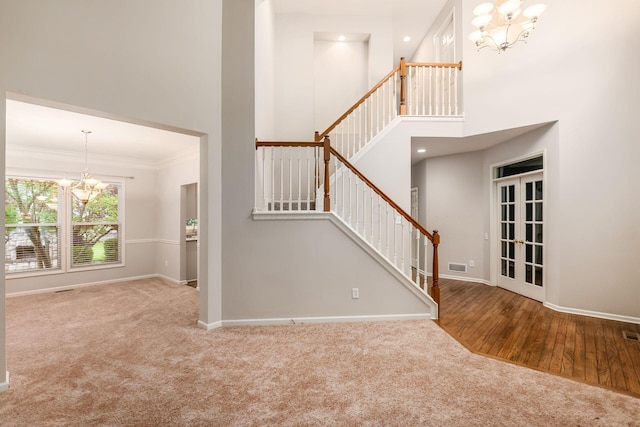 7985 Eric Ct, Lewis Center, OH 43035 - stairs with a chandelier, carpet flooring, a towering ceiling, baseboards, and crown molding