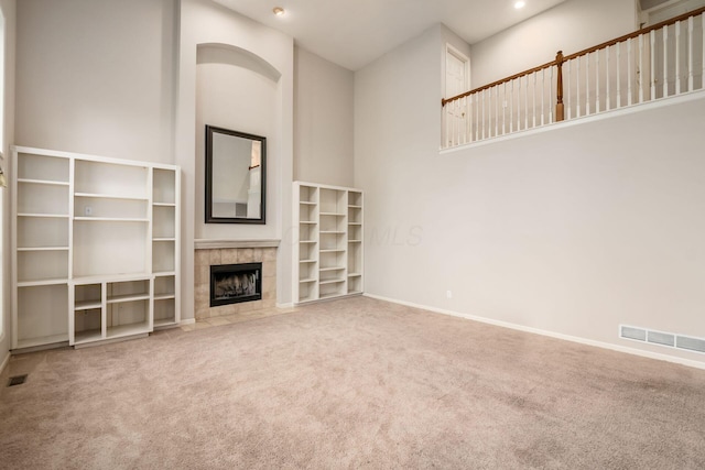 7985 Eric Ct, Lewis Center, OH 43035 - unfurnished living room featuring carpet, a tile fireplace, a towering ceiling, recessed lighting, and baseboards