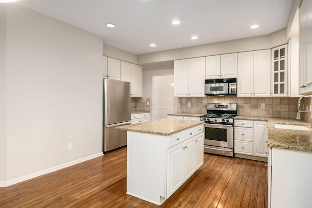 7985 Eric Ct, Lewis Center, OH 43035 - kitchen with appliances with stainless steel finishes, a sink, wood-type flooring, a center island, and recessed lighting