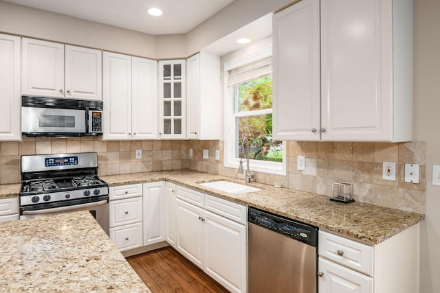 7985 Eric Ct, Lewis Center, OH 43035 - kitchen featuring appliances with stainless steel finishes, wood finished floors, glass insert cabinets, white cabinetry, and recessed lighting