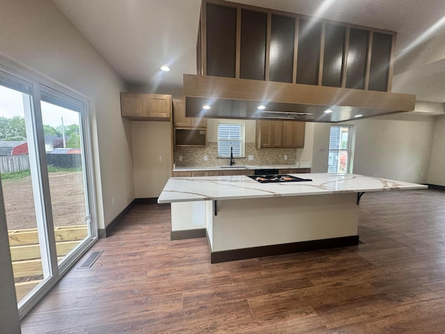 1624 Marlboro Ave, Obetz, OH 43207 - kitchen featuring dark wood finished floors, tasteful backsplash, a kitchen breakfast bar, a spacious island, and light stone countertops