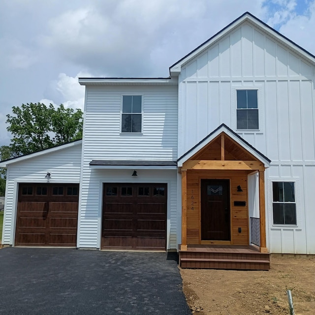 1624 Marlboro Ave, Obetz, OH 43207 - view of front of house with board and batten siding, asphalt driveway, and an attached garage