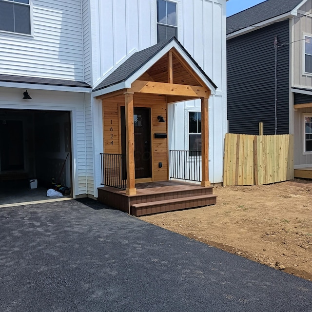 1624 Marlboro Ave, Obetz, OH 43207 - doorway to property with board and batten siding, a garage, and asphalt driveway