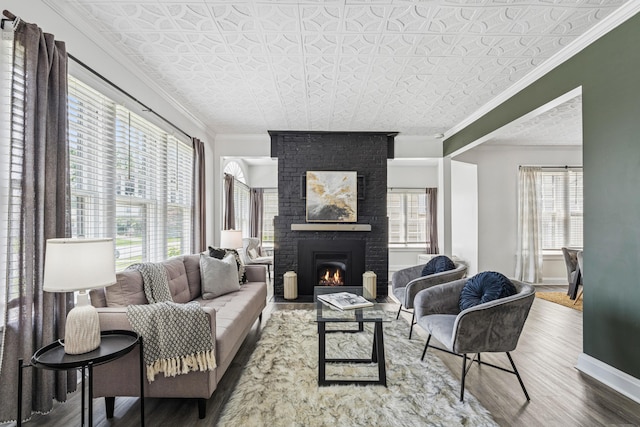 211 Guernsey Ave, Columbus, OH 43204 - living room featuring an ornate ceiling, wood finished floors, ornamental molding, a brick fireplace, and baseboards