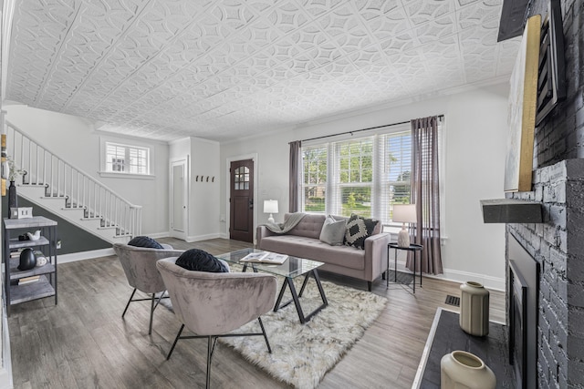 211 Guernsey Ave, Columbus, OH 43204 - living area featuring stairway, wood finished floors, baseboards, a fireplace, and an ornate ceiling