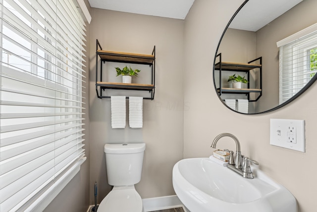 211 Guernsey Ave, Columbus, OH 43204 - bathroom featuring baseboards, toilet, and a sink