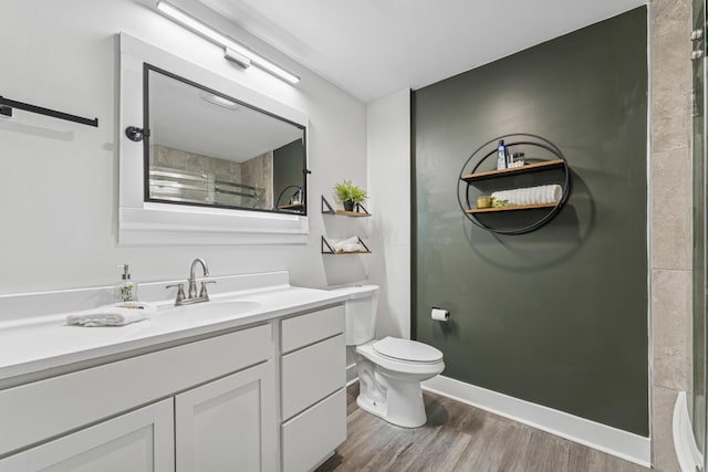 211 Guernsey Ave, Columbus, OH 43204 - full bathroom with vanity, wood finished floors, toilet, a shower, and baseboards