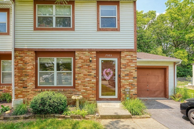 7581-7583 Pickett Ln Unit 83, Columbus, OH 43235 - townhome / multi-family property with driveway, brick siding, an attached garage, and roof with shingles