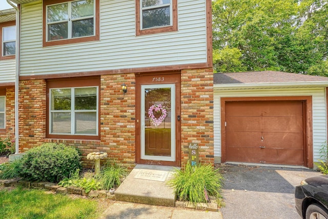 7581-7583 Pickett Ln Unit 83, Columbus, OH 43235 - townhome / multi-family property with brick siding, asphalt driveway, a garage, and roof with shingles