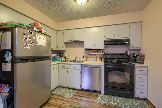 7581-7583 Pickett Ln Unit 83, Columbus, OH 43235 - kitchen featuring stainless steel appliances, under cabinet range hood, a sink, a textured ceiling, and wood finished floors