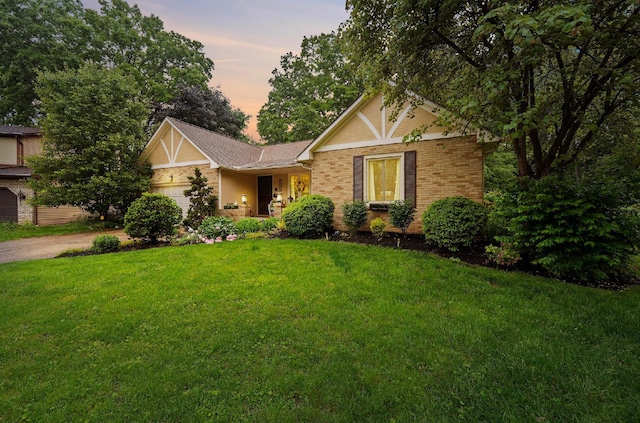 1027 Peggys Cv, Reynoldsburg, OH 43068 - tudor home featuring a garage, a front lawn, driveway, and brick siding