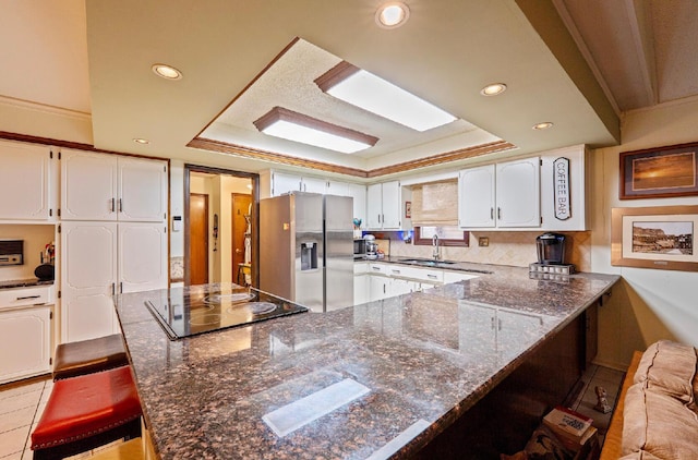1027 Peggys Cv, Reynoldsburg, OH 43068 - kitchen featuring stainless steel fridge with ice dispenser, a sink, a raised ceiling, a peninsula, and black electric stovetop