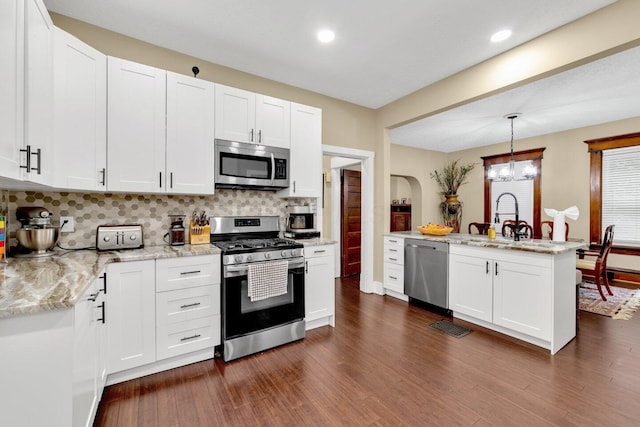 540 Linwood Ave, Columbus, OH 43205 - kitchen featuring stainless steel appliances, decorative backsplash, white cabinetry, dark wood-style floors, and recessed lighting