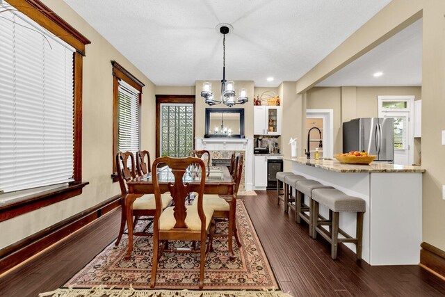 540 Linwood Ave, Columbus, OH 43205 - dining room with beverage cooler, dark wood finished floors, a chandelier, baseboards, and recessed lighting