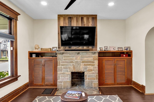 540 Linwood Ave, Columbus, OH 43205 - living room with baseboards, wood finished floors, arched walkways, recessed lighting, and a stone fireplace