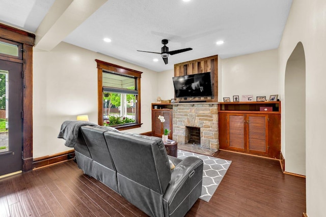 540 Linwood Ave, Columbus, OH 43205 - living area with arched walkways, a ceiling fan, baseboards, a stone fireplace, and wood finished floors