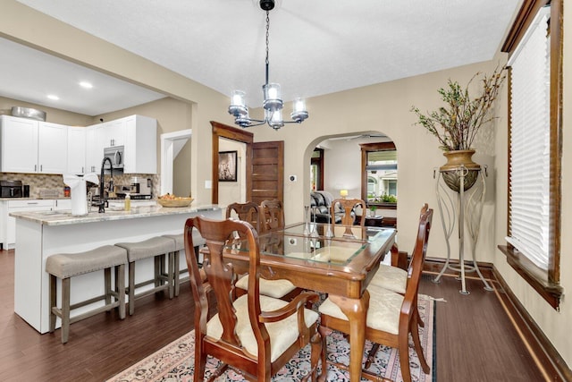 540 Linwood Ave, Columbus, OH 43205 - dining space featuring arched walkways, dark wood finished floors, a chandelier, recessed lighting, and a textured ceiling