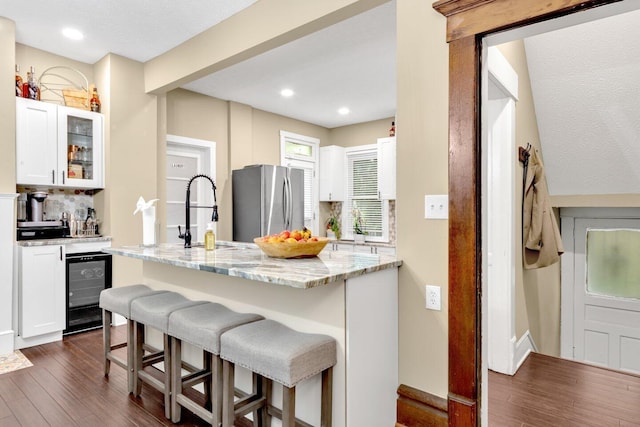 540 Linwood Ave, Columbus, OH 43205 - kitchen with wine cooler, a breakfast bar area, a sink, dark wood-style floors, and white cabinetry