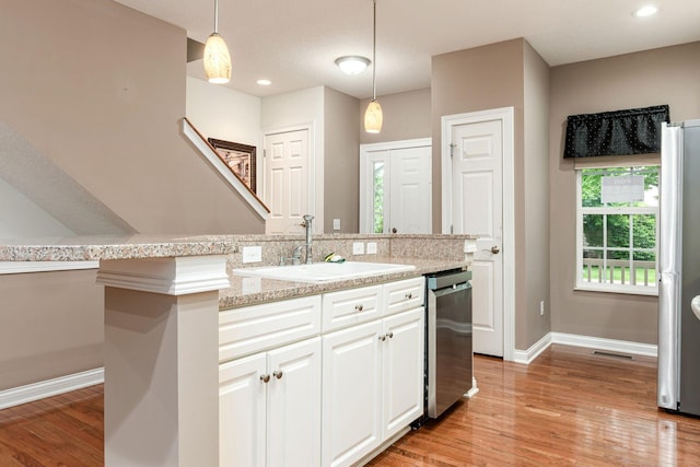 6618 Wild Rose Ln, Westerville, OH 43082 - kitchen with appliances with stainless steel finishes, a sink, white cabinets, light wood-type flooring, and recessed lighting
