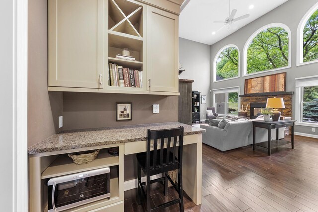 6034 Heritage View Ct, Hilliard, OH 43026 - kitchen with a high ceiling, light stone countertops, open floor plan, dark wood-type flooring, and a ceiling fan