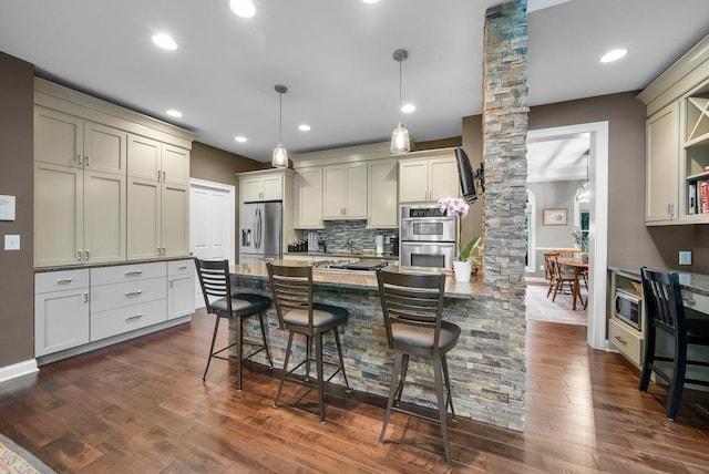 6034 Heritage View Ct, Hilliard, OH 43026 - kitchen featuring decorative columns, appliances with stainless steel finishes, a peninsula, dark wood finished floors, and a kitchen breakfast bar