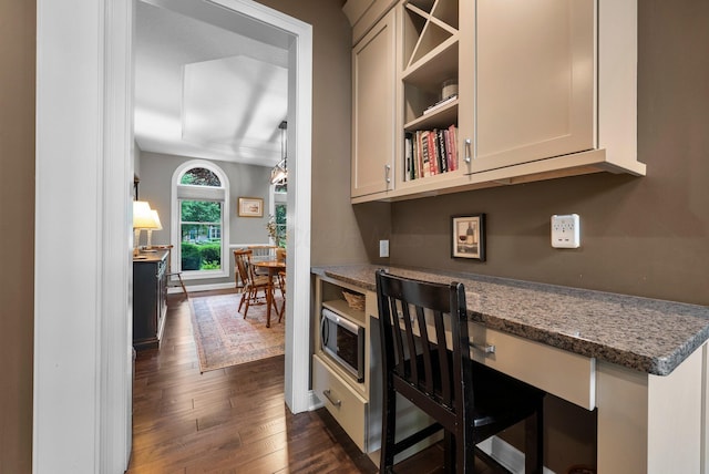 6034 Heritage View Ct, Hilliard, OH 43026 - kitchen with stainless steel microwave, dark wood finished floors, stone countertops, and baseboards
