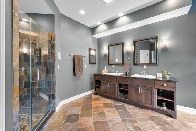 6034 Heritage View Ct, Hilliard, OH 43026 - bathroom with baseboards, double vanity, stone tile flooring, a stall shower, and recessed lighting