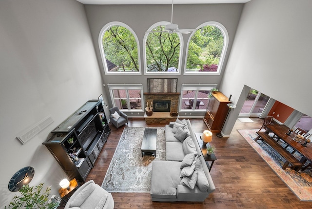 6034 Heritage View Ct, Hilliard, OH 43026 - living room with healthy amount of natural light, a stone fireplace, ceiling fan, wood finished floors, and a towering ceiling