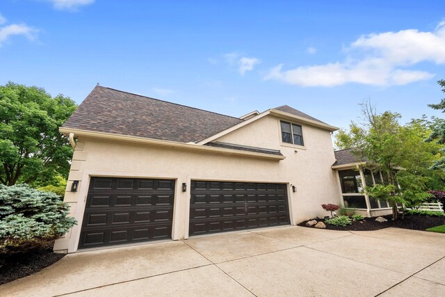 6034 Heritage View Ct, Hilliard, OH 43026 - view of front of property featuring concrete driveway, stucco siding, a shingled roof, a sunroom, and a garage