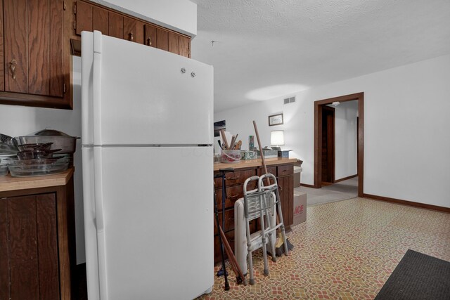 7682 Northridge Rd, Johnstown, OH 43031 - kitchen featuring freestanding refrigerator, baseboards, light countertops, and a textured ceiling