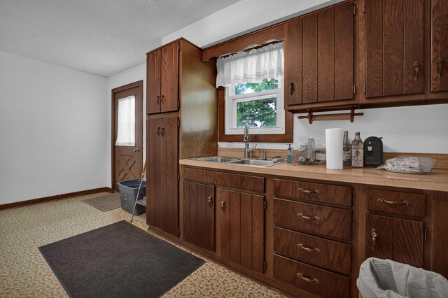 7682 Northridge Rd, Johnstown, OH 43031 - kitchen featuring a sink, plenty of natural light, baseboards, light countertops, and a textured ceiling