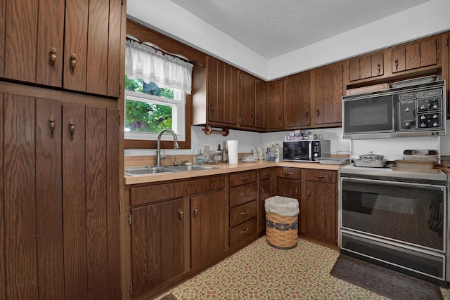 7682 Northridge Rd, Johnstown, OH 43031 - kitchen with black microwave, range with electric cooktop, a sink, light countertops, and a textured ceiling