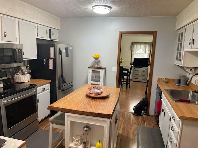 314 Broken Arrow Rd, Columbus, OH 43230 - kitchen with appliances with stainless steel finishes, butcher block countertops, a sink, dark wood-style floors, and white cabinets