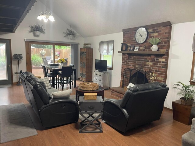 314 Broken Arrow Rd, Columbus, OH 43230 - living room featuring wood finished floors, a brick fireplace, a chandelier, and high vaulted ceiling