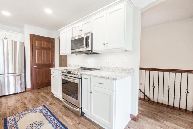 51 Appletree Ct, Howard, OH 43028 - kitchen featuring appliances with stainless steel finishes, light wood-type flooring, white cabinetry, recessed lighting, and light stone countertops