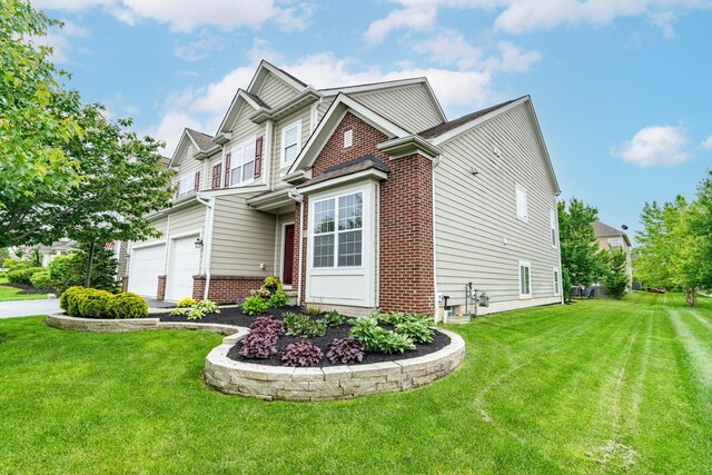 2505 Isabella Blue Dr, Powell, OH 43065 - view of side of property featuring brick siding, an attached garage, and a lawn