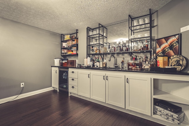 2505 Isabella Blue Dr, Powell, OH 43065 - indoor bar featuring beverage cooler, dark wood-style flooring, baseboards, and a textured ceiling