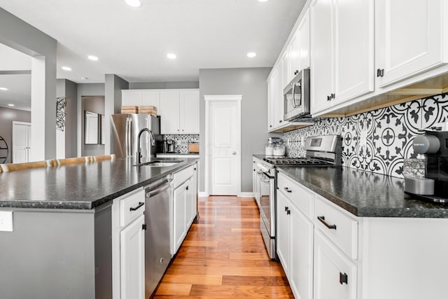 2505 Isabella Blue Dr, Powell, OH 43065 - kitchen featuring appliances with stainless steel finishes, a sink, light wood finished floors, backsplash, and recessed lighting