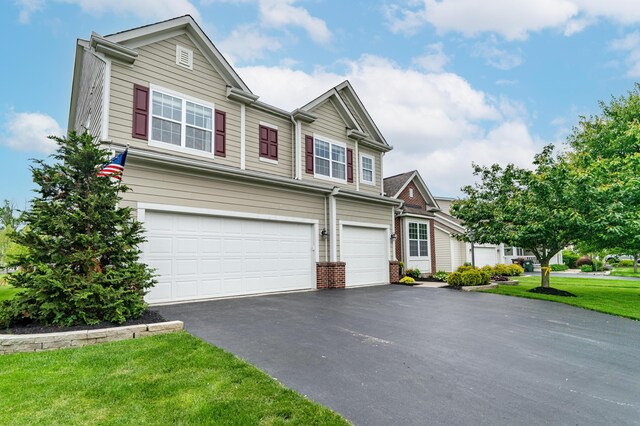 2505 Isabella Blue Dr, Powell, OH 43065 - view of front of house featuring a garage, driveway, a front lawn, and brick siding