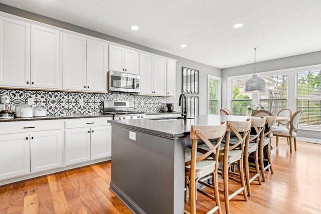 2505 Isabella Blue Dr, Powell, OH 43065 - kitchen with appliances with stainless steel finishes, a sink, light wood-style floors, tasteful backsplash, and recessed lighting