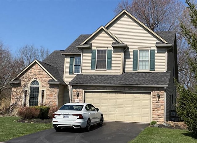 1315 Shelby Cir, Reynoldsburg, OH 43068 - view of front of home featuring asphalt driveway, an attached garage, stone siding, and a shingled roof