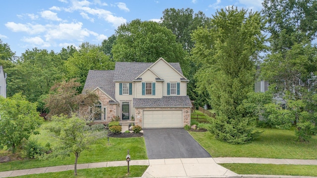 1315 Shelby Cir, Reynoldsburg, OH 43068 - view of front of home featuring asphalt driveway, a front yard, an attached garage, and stone siding